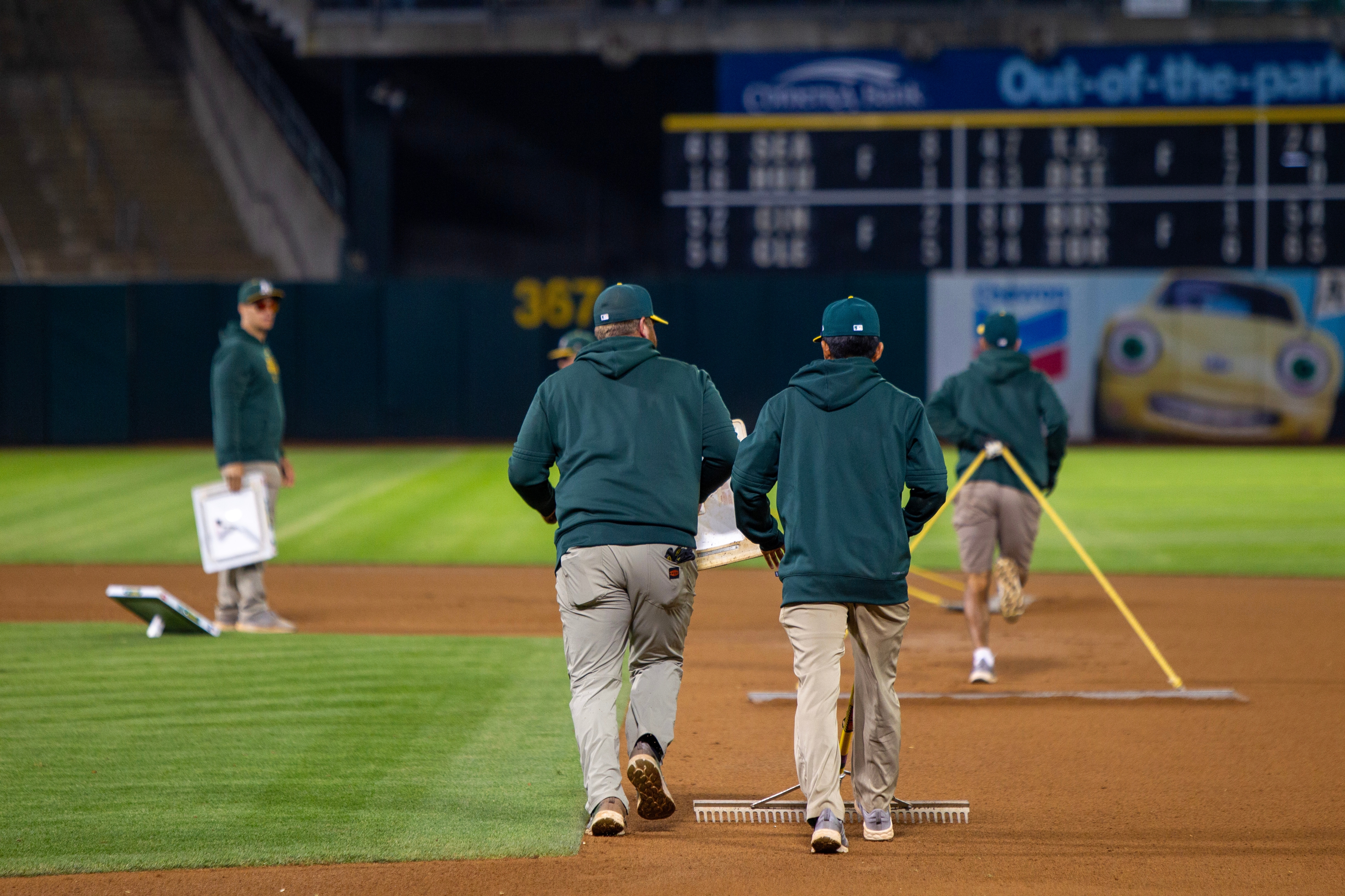 grounds crew raking the infield of a baseball stadium